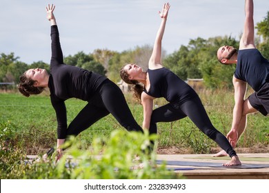 Group Of Young People Practicing In An Outdoor Yoga Class