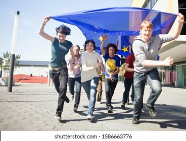 Group of young people running with an EU flag in Munich, Bavaria, Germany