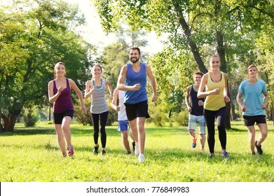 Group Of Young People Running In Park