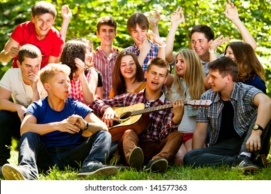 Group Of Young People Singing In Unison By Guitar