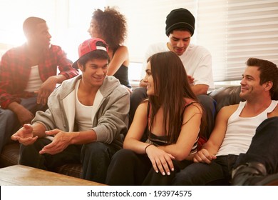 Group Of Young People Sitting On Sofa And Talking