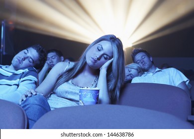 Group of young people sleeping while watching movie in the theatre - Powered by Shutterstock