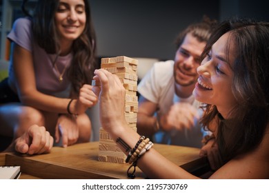 Group of young people spending time together at home, they are playing Jenga - Powered by Shutterstock