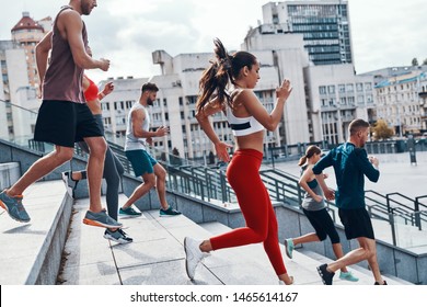 Group of young people in sports clothing jogging while exercising on the stairs outdoors                  - Shutterstock ID 1465614167