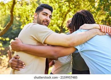 Group Of Young People Stand In A Circle And Hug Each Other For Community And Team Spirit