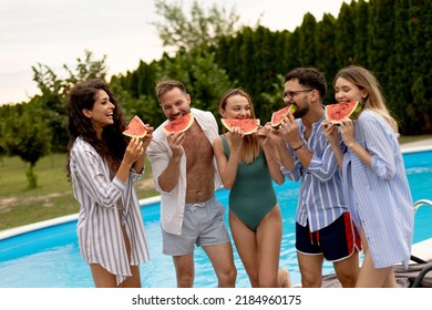 Group Of Young People Standing By The Swimming Pool And Eating Watermellon In The House Backyard