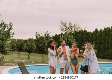 Group Of Young People Standing By The Swimming Pool And Eating Watermellon In The House Backyard