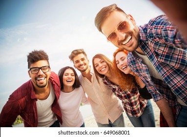 Group Of Young People Standing In A Circle, Outdoors, Making A Selfie  