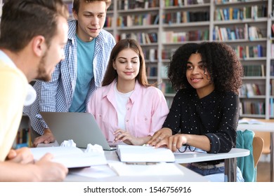Group of young people studying at table in library - Shutterstock ID 1546756916