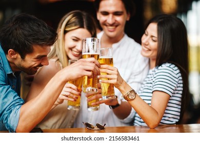 Group of young people at a summer bar toast with beer - Powered by Shutterstock