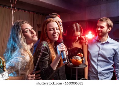 Group Of Young People Together In Karaoke Bar, Singing And Having Fun Together, Clubbers Rocking And Chilling Out In Karaoke. Celebration, Holiday, Birthday Concept