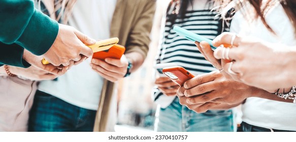 Group of young people using smart mobile phone device outside - Teenagers addicted to social media - Technology life style concept - Powered by Shutterstock