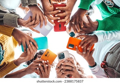 Group of young people using smart mobile phone device outside - Trendy technology concept with guys and girls playing video games app on smartphone - Bright colorful filter - Powered by Shutterstock