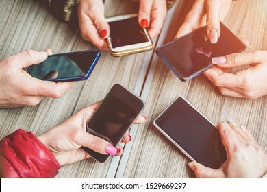 Group of young people using smartphones - Hands view of happy friends having fun with mobile phones apps - New technology trends, influencer and commute concept - Main focus on left bottom cellphones 