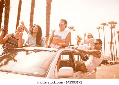 Group Of Young People At Venice Beach In Los Angeles Flying A Kite From A Car