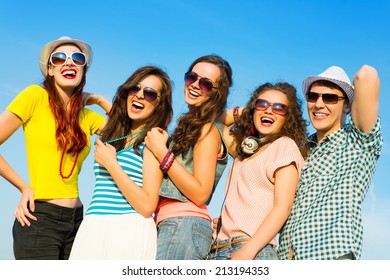 group of young people wearing sunglasses and hats hugging and standing in a row, spending time with friends - Shutterstock ID 213194353