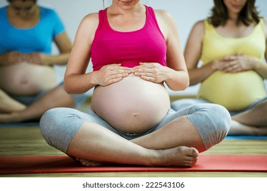 Group of young pregnant women doing relaxation exercise on exercising mat
