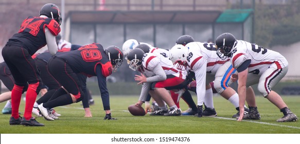 Group Of Young Professional American Football Players Ready To Start During Training Match On The Stadium Field