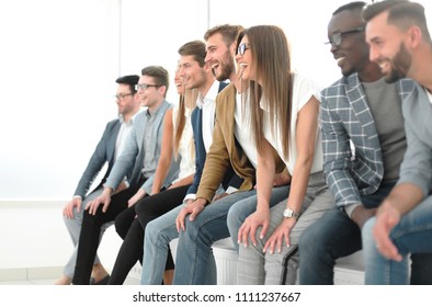 Group Of Young Professionals Sitting Near The Wall