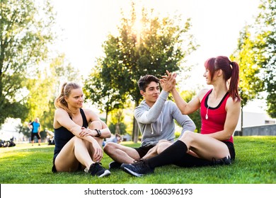 Group Of Young Runners Resting In A Park.