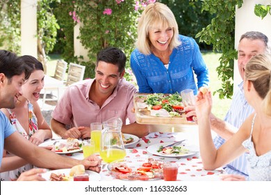 Group Of Young And Senior Couples Enjoying Family Meal - Powered by Shutterstock