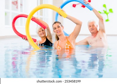 Group  or young and senior people in aquarobic fitness swimming pool exercising with  pool noodle - Powered by Shutterstock