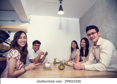 Group Of Young Singaporean Adult Talking And Meeting Together In Coffee Shop.