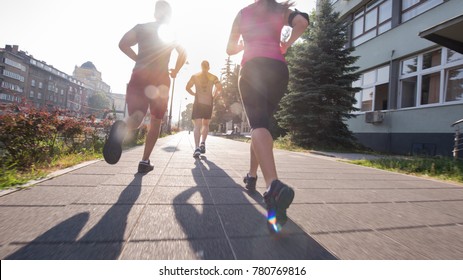 Group Of Young Sporty People Jogging At Sunny Morning In The City