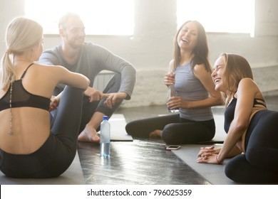 Group Of Young Sporty People Sitting In Circle Having A Break. Friends Laughing With Joy, Feeling Excited About Training, Sitting On The Floor, Feeling Fatigued But Nice After Good Exercising