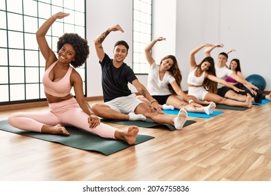 Group Of Young Sporty People Smiling Happy Training Yoga At Sport Center.