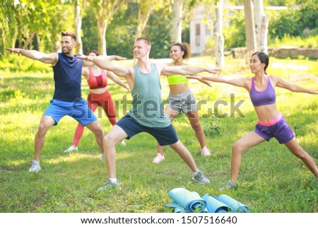 Group of young sporty people training together outdoors