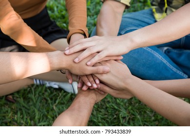 Group of young student team put all hands together on grass background outdoor, hands of team