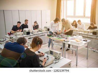 Group Of Young Students Doing Technical Vocational Practice With Teacher In The Electronic Classroom, Education And Technology Concept