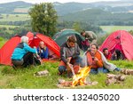 Group of young students spending weekend together in tents campfire