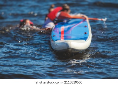 Group of young sup surfers fall from SUP stand up paddle board, women drowning, concept of fail solving problems, team work and survival, boat accident during stand up paddling, standup paddleboarding