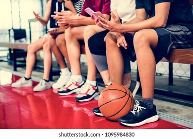 Group of young teenager friends on a basketball court relaxing using smartphone addiction concept - Powered by Shutterstock