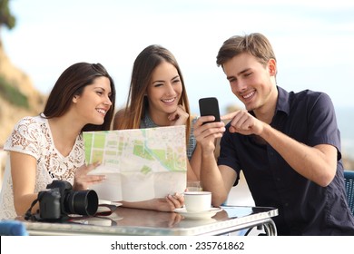 Group of young tourist friends consulting gps map in a smart phone in a restaurant with the beach in the background - Powered by Shutterstock