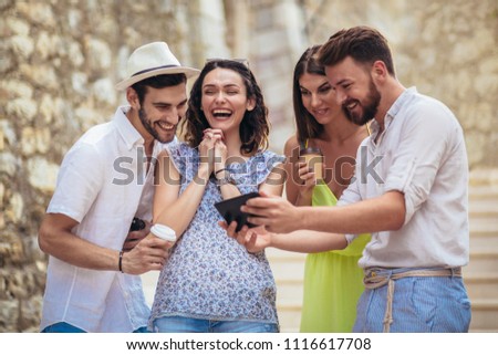 Similar – Young happy people looking tablet over table