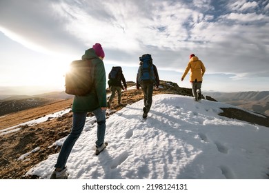 Group of young tourists hikers walks on mountain top with backpacks. Active life concept - Shutterstock ID 2198124131