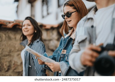 Group of young tourists with a map and camera, exploring the old streets of a city, enjoying their vacation on a sunny day. - Powered by Shutterstock