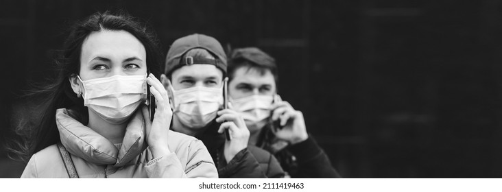 Group Of Young Volunteers Wearing Face Masks With Mobile Phones. Volunteers Are Ready To Help.  The Concept Of Mutual Assistance And Support. 