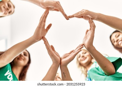 Group of young volunteers woman smiling happy make heart symbol with hands together at charity center. - Powered by Shutterstock