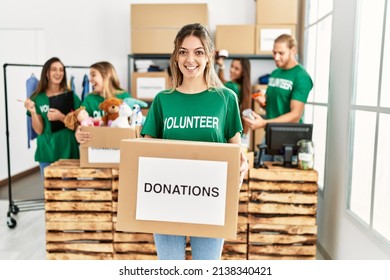 Group of young volunteers working at charity center. Man smiling happy and holding dontations box. - Powered by Shutterstock