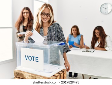 Group of young voter woman smiling happy putting vote in voting box at electoral center.