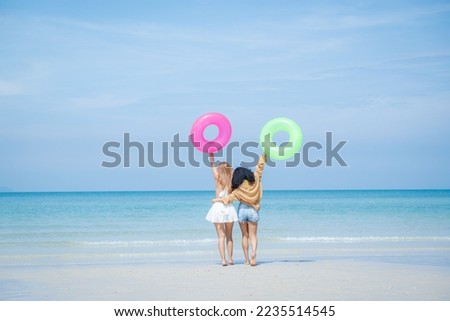 Group of young woman having fun playing on the beach together. Attractive woman friends feeling happiness and fun at seaside enjoy vacation holiday.