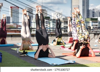 Group Of Young Women Exercising On The Roof By Doing Yoga