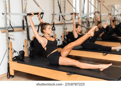 Group of young women exercising on pilates reformers beds - Shutterstock ID 2318787225