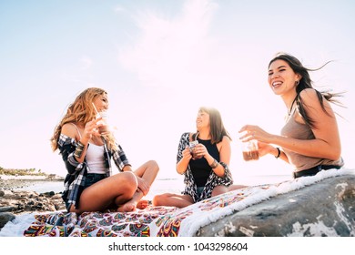 Group Of Young Women Friend Drinking Together A Fruit Juice On A Rock Beach In Tenerife. Relationship For A Team To Ejoy The Vacation And Happiness.