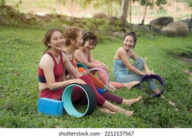 A Group Of Young Women Are Practicing Yoga Beside The Mountain By The Stream In The Morning.