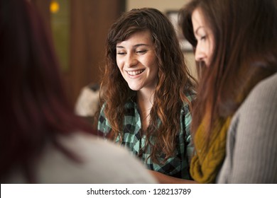 A group of young women sit together and smile.